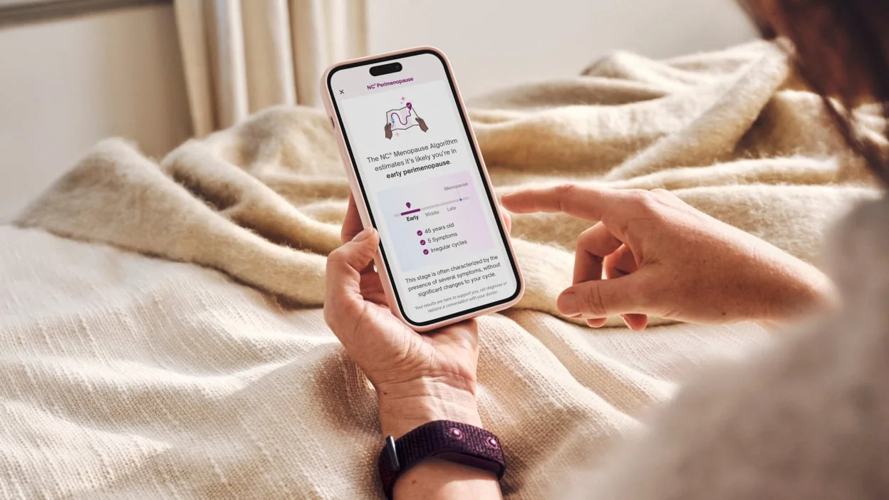 Femme mûre utilisant une application de suivi de cycle pour identifier l'âge de la ménopause.